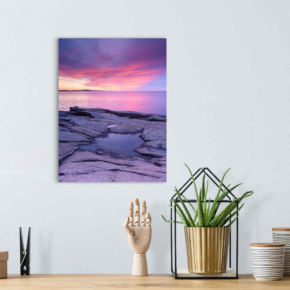 A bohemian room featuring Pink and purple photograph of a beautiful sunset over the water and a frozen puddle of water on t...