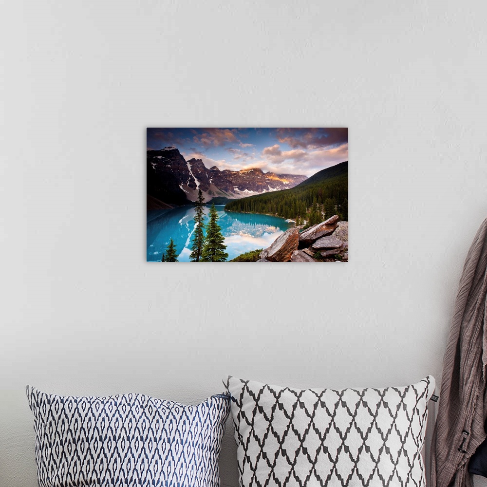 A bohemian room featuring Landscape photograph of Lake Moraine surrounded bu snowy mountains and pine trees.