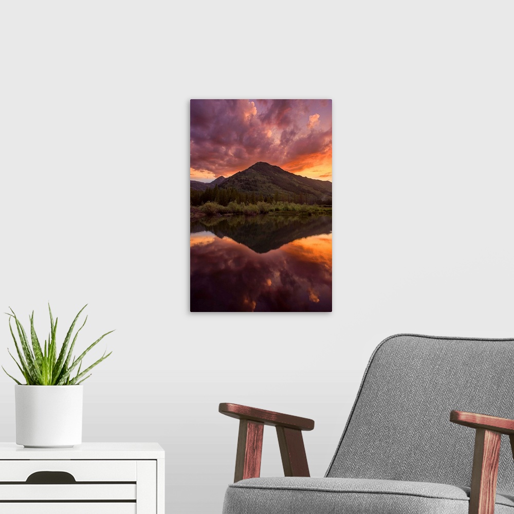 A modern room featuring A photograph of a mountain seen under an orange sunset sky.