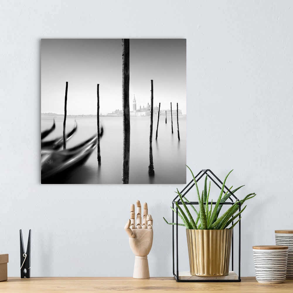 A bohemian room featuring An artistic black and white photograph of gondola docked at harbor in Venice.