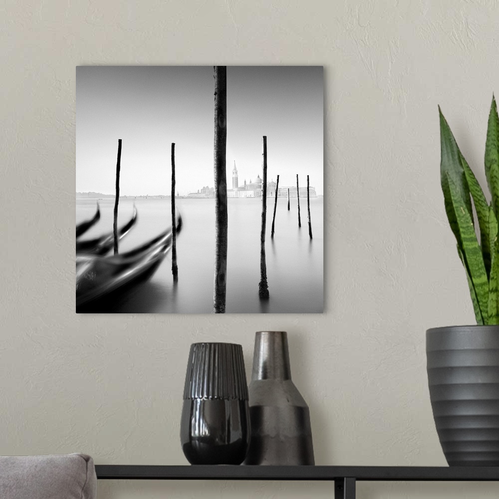 A modern room featuring An artistic black and white photograph of gondola docked at harbor in Venice.