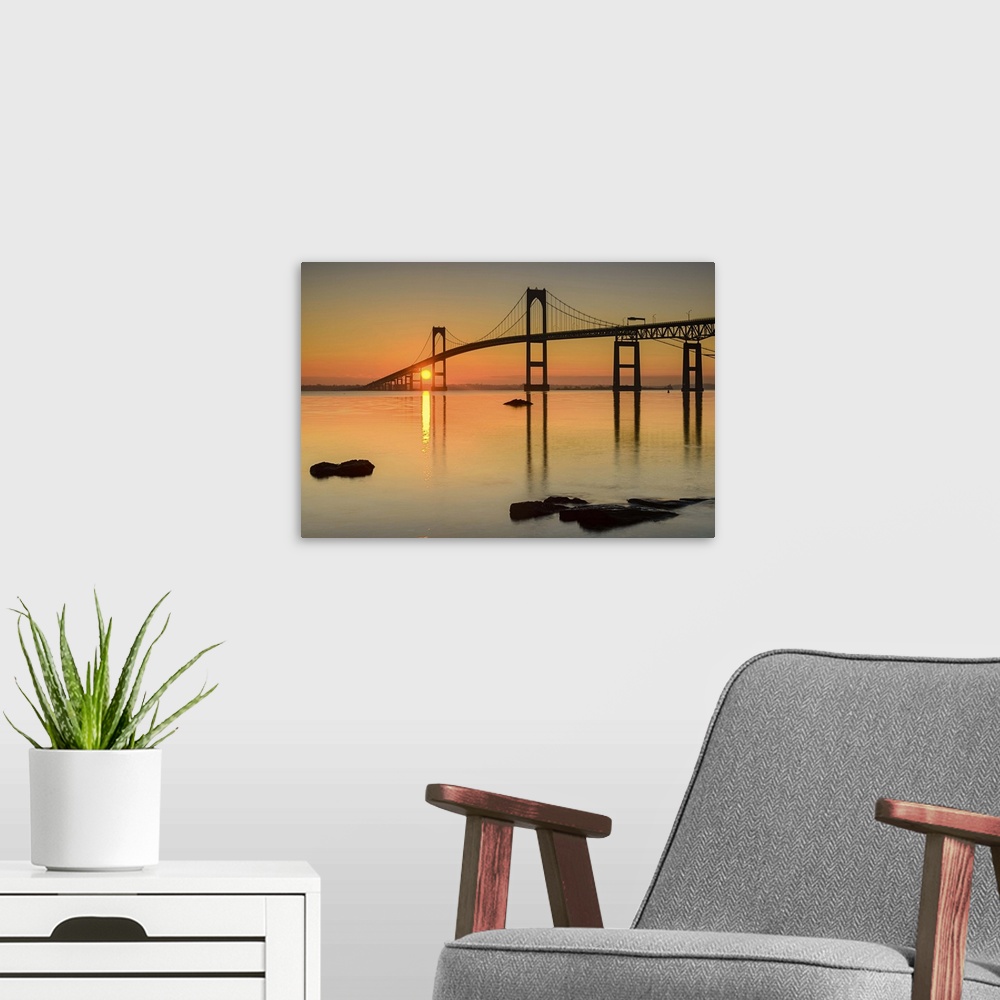 A modern room featuring A photograph of a large suspension bridge silhouetted at sunset.