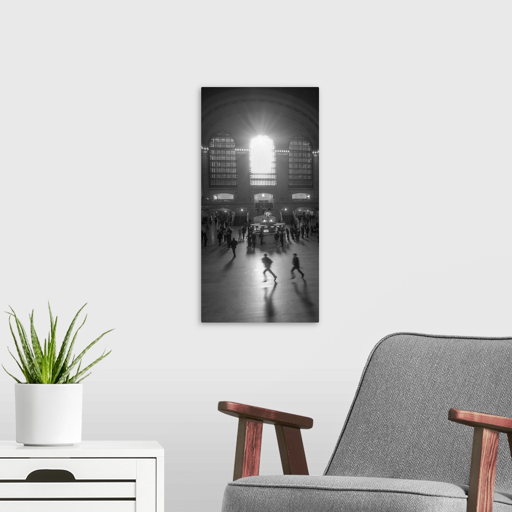A modern room featuring An artistic black and white photograph of silhouetted people inside Grand Central Station.