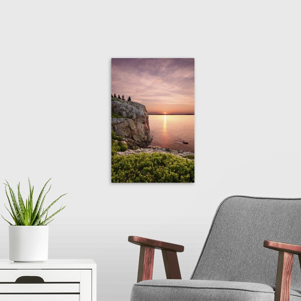 A modern room featuring An artistic photograph of a cliff-side view of a sunset out to sea.
