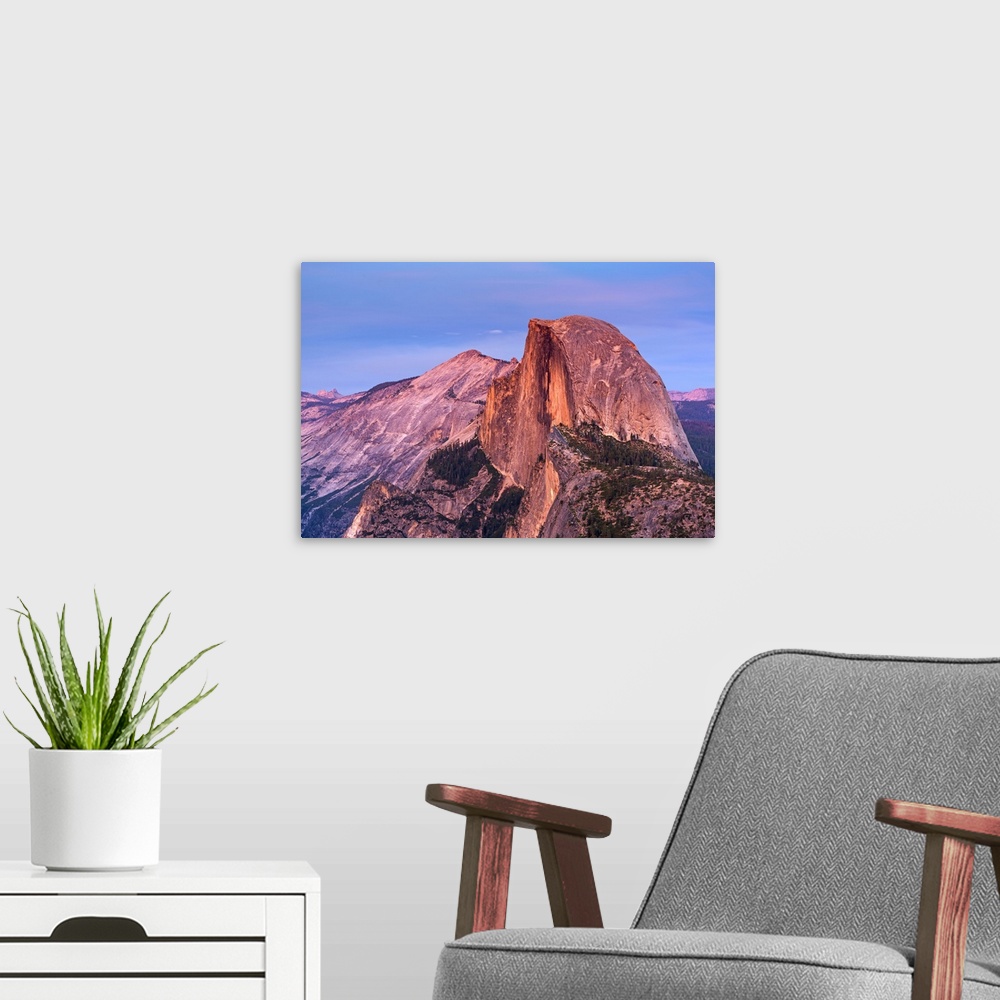 A modern room featuring Half Dome in Yosemite bathed in pink light from the sunset.