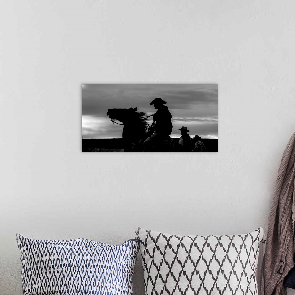 A bohemian room featuring Black and white silhouette photograph of a cowboy on horseback.