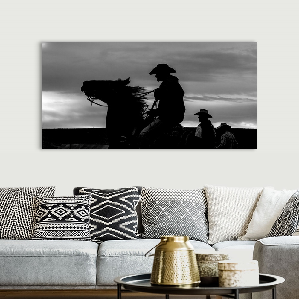 A bohemian room featuring Black and white silhouette photograph of a cowboy on horseback.