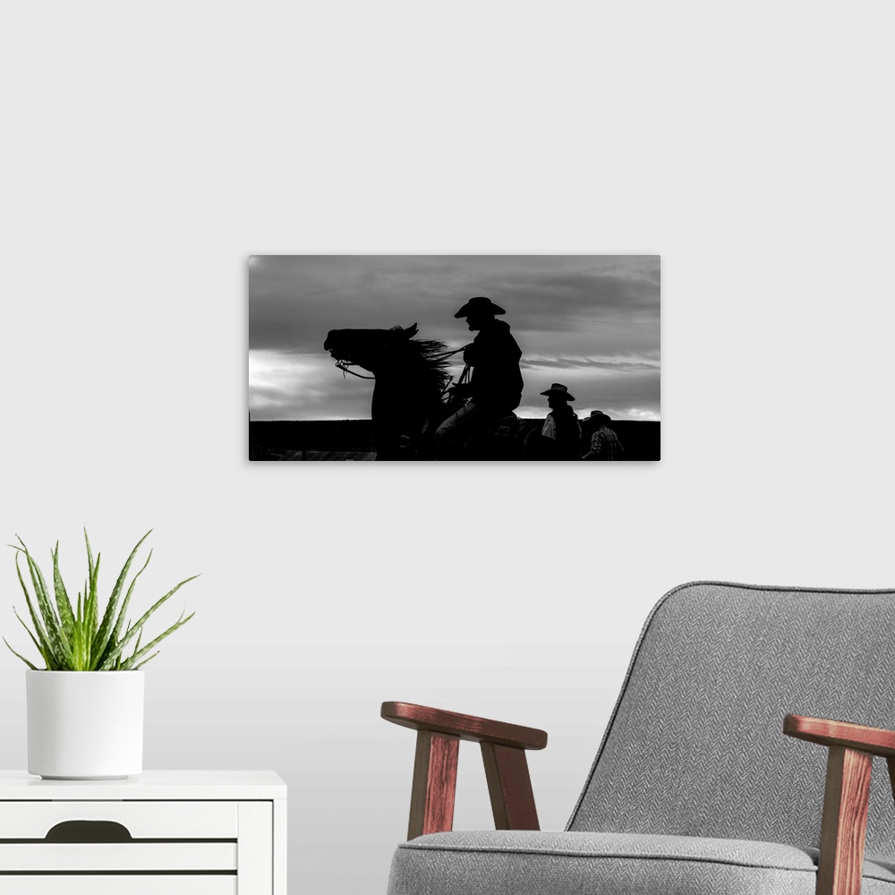 A modern room featuring Black and white silhouette photograph of a cowboy on horseback.