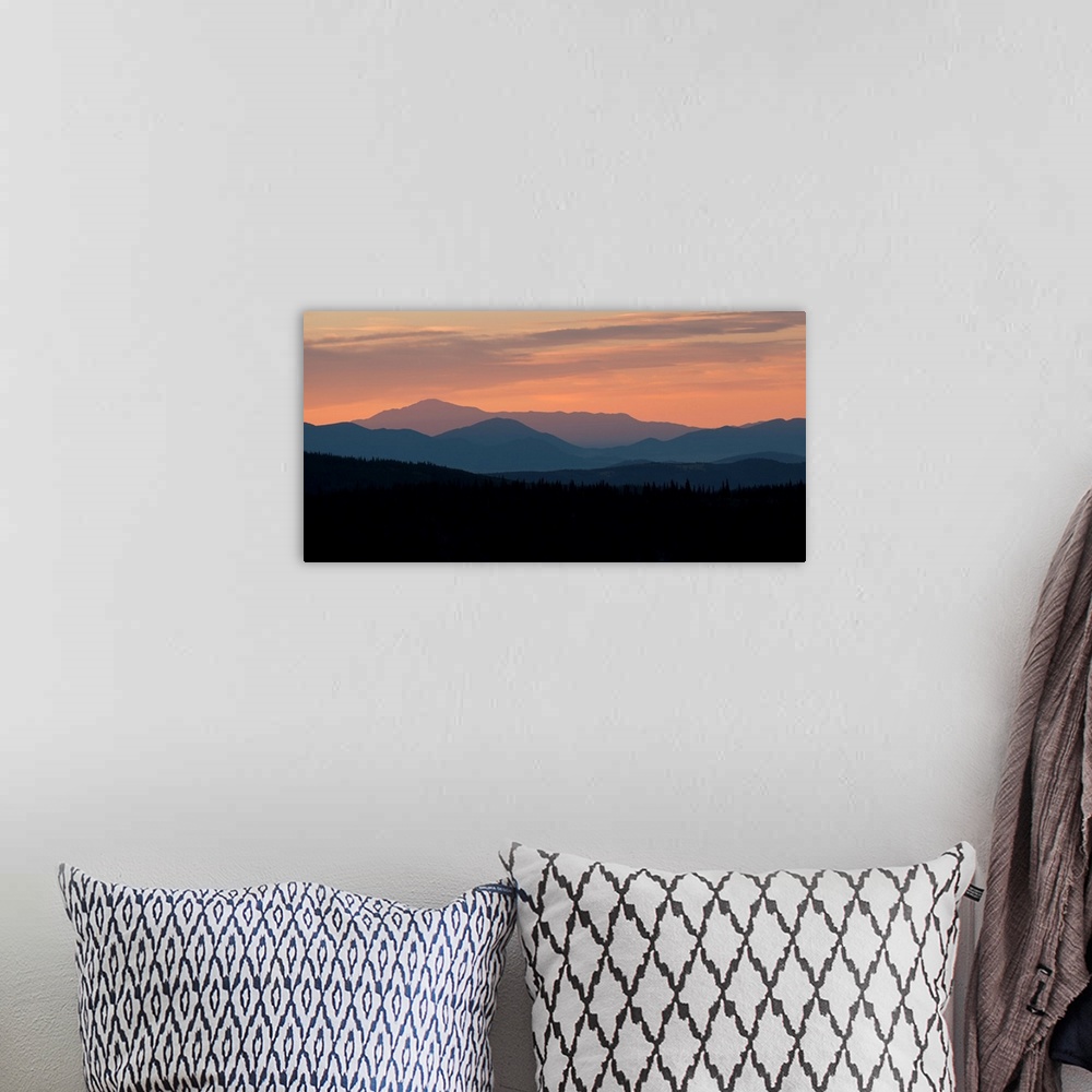A bohemian room featuring Landscape photograph of a silhouetted mountain range at sunset.