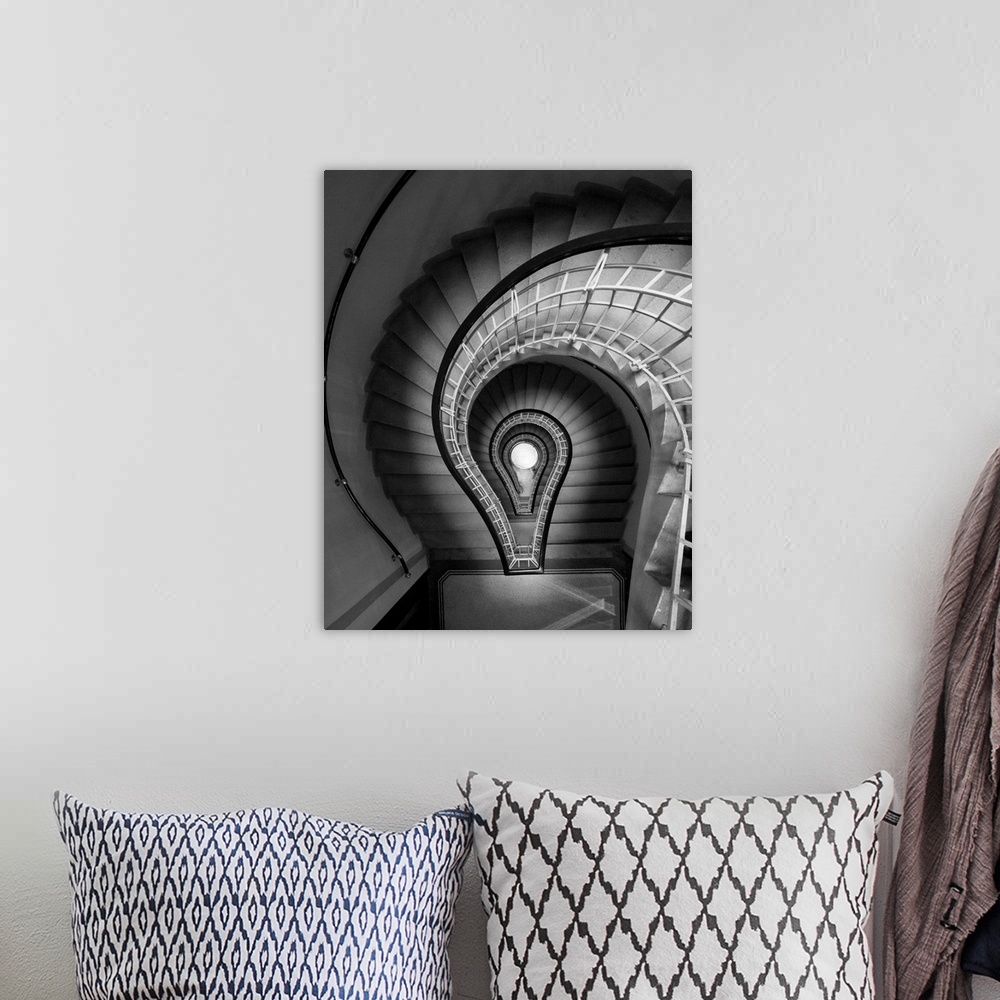 A bohemian room featuring black and white photograph, stairs, spiral staircase, lightbulb