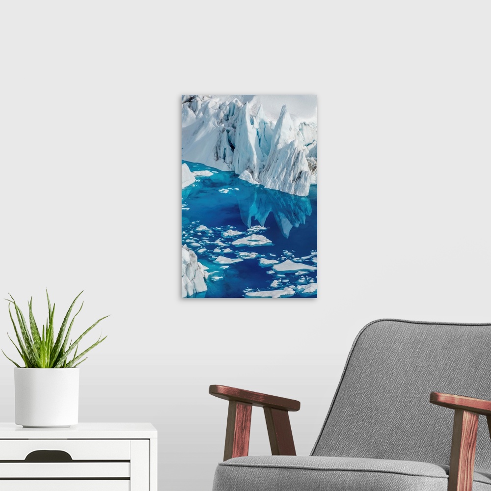 A modern room featuring Landscape photograph of an iceberg reflecting onto bright blue water.