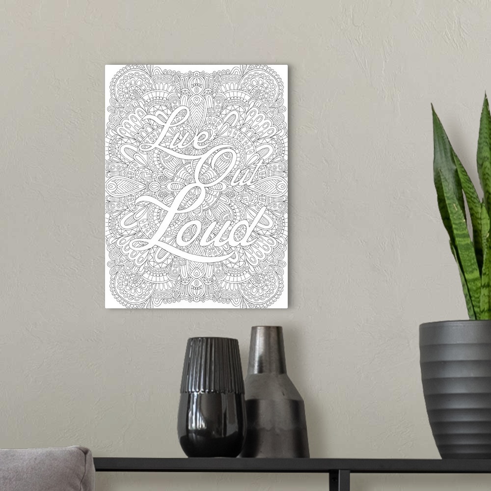 A modern room featuring Inspirational black and white line art with the phrase "Live Out Loud" written in front of an int...