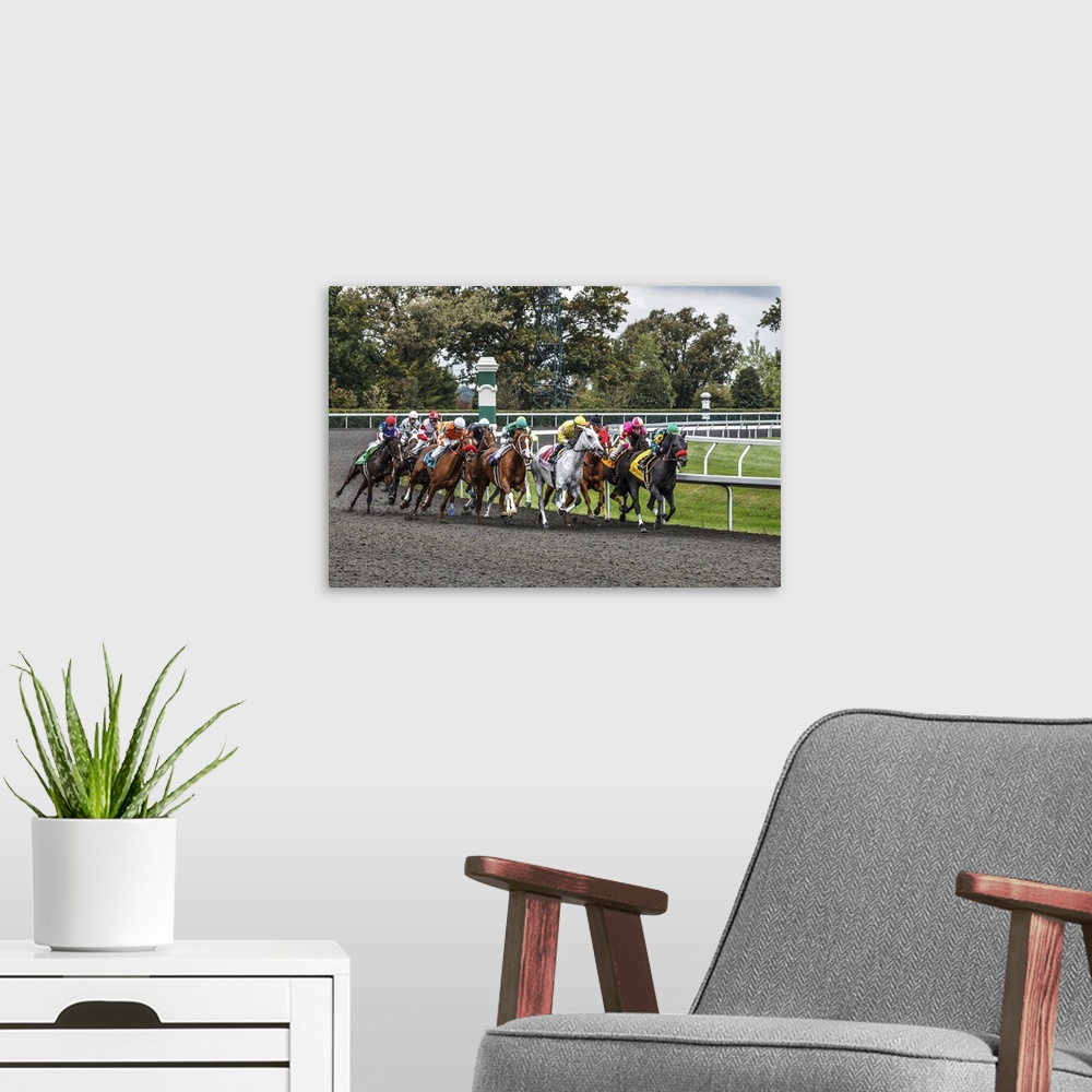A modern room featuring Photograph of a a horse race at full speed rounding a curve.