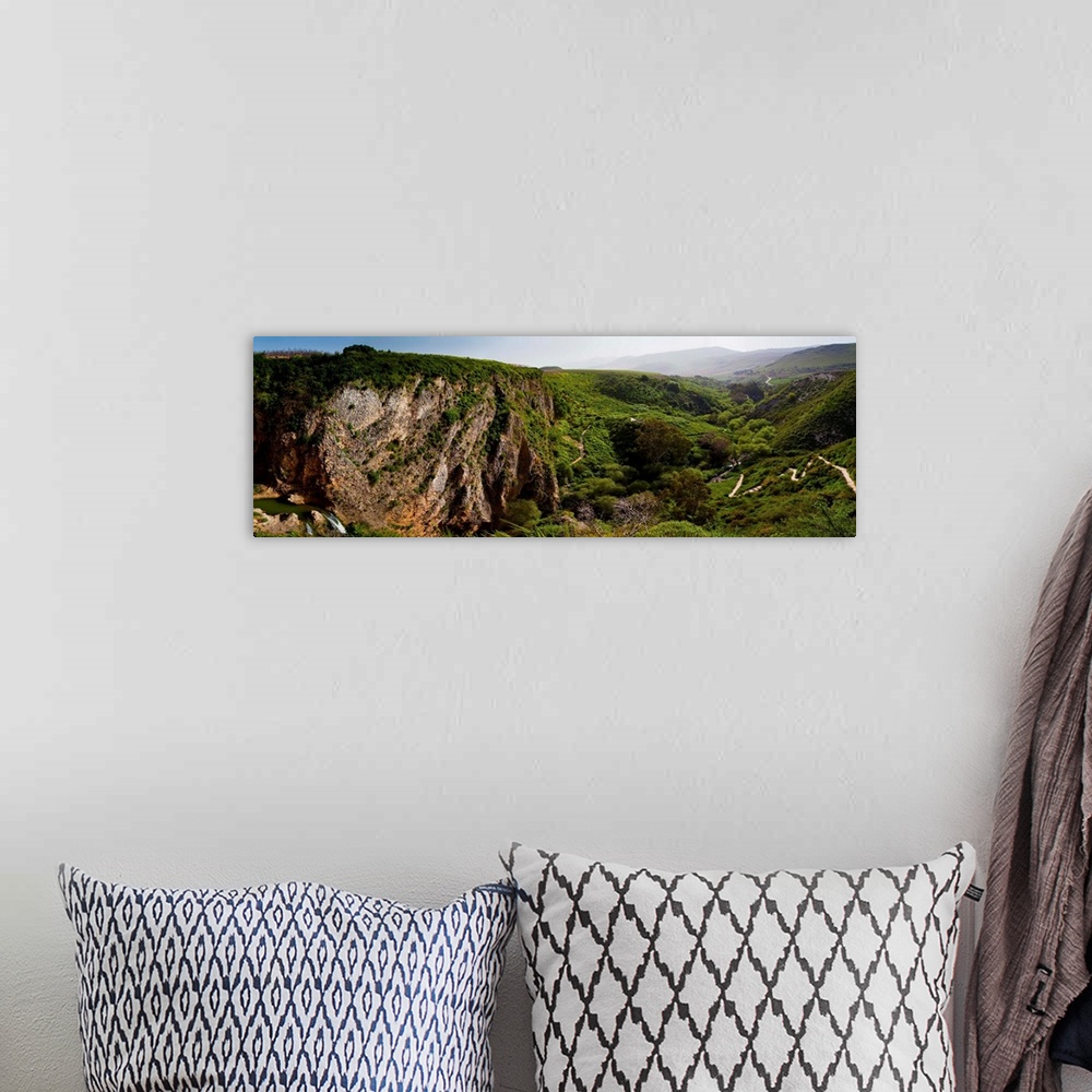 A bohemian room featuring Panoramic photograph of low mountains in Israel with fog.