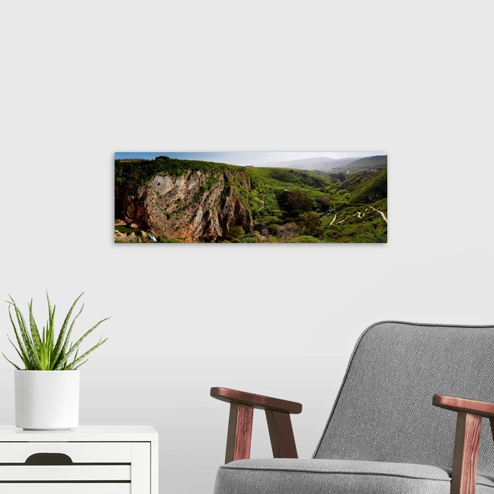A modern room featuring Panoramic photograph of low mountains in Israel with fog.