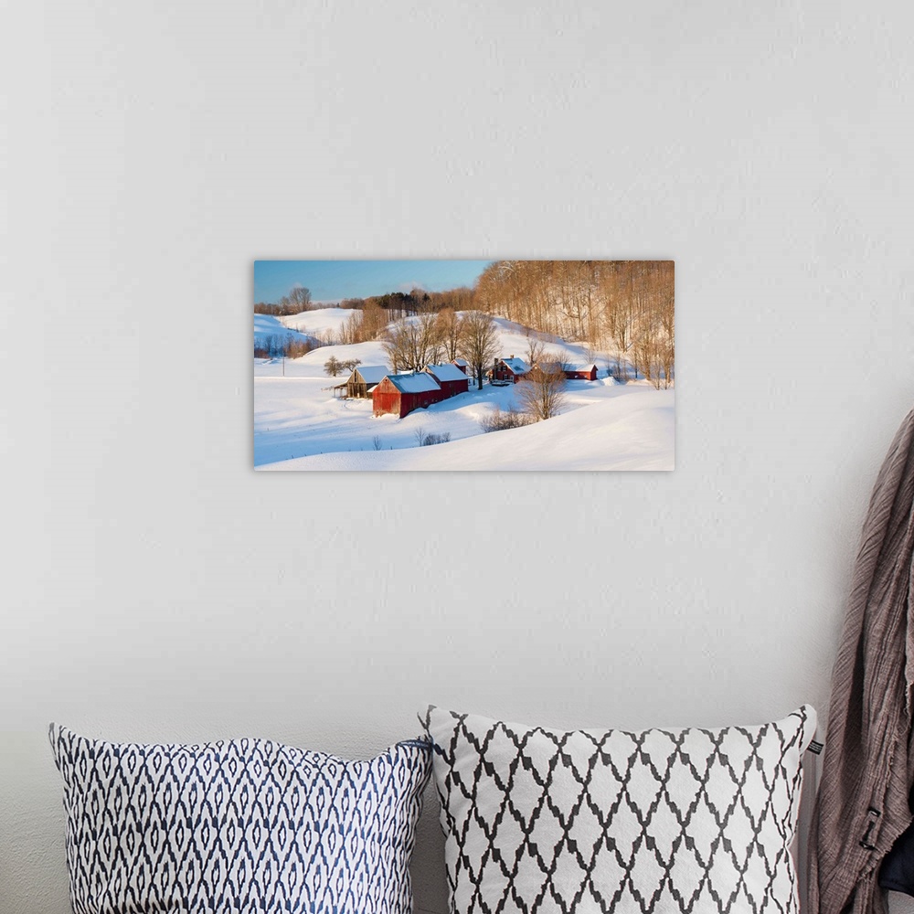 A bohemian room featuring Landscape photograph of snowy farmland with red buildings and bare trees in Winter.