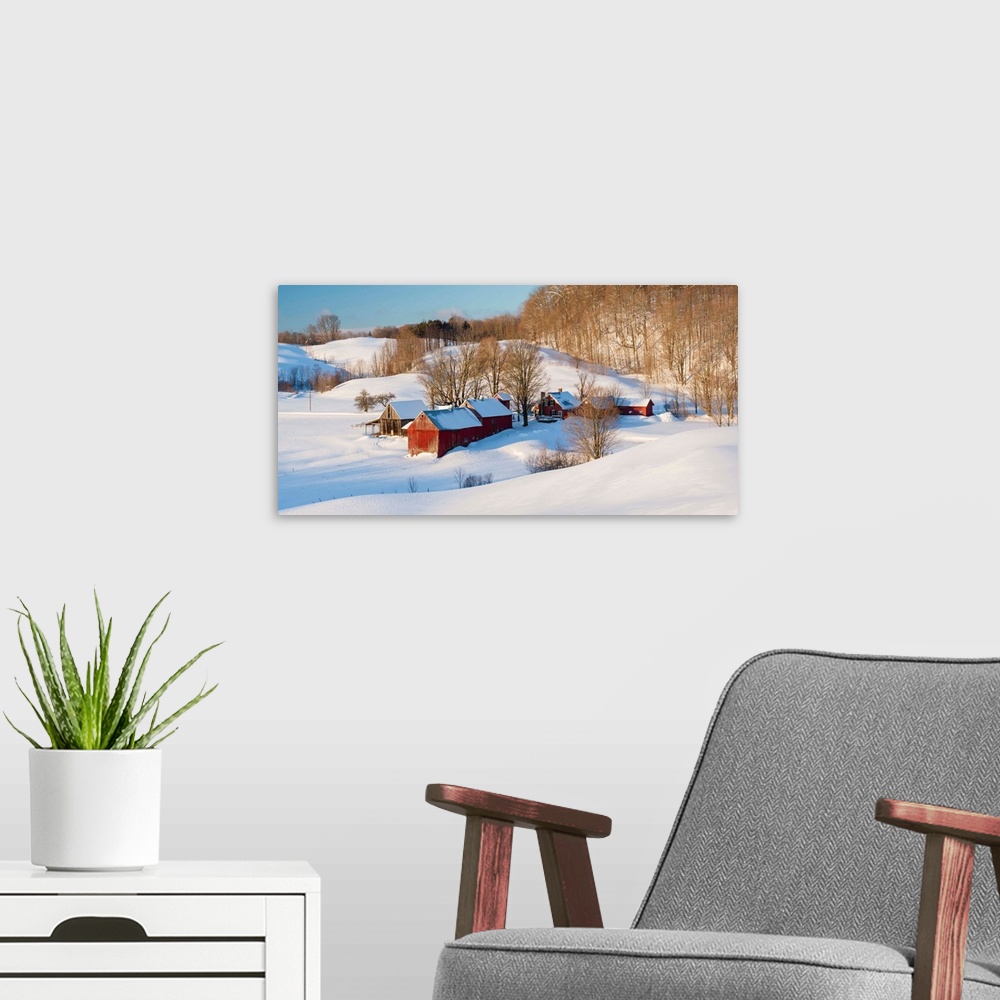 A modern room featuring Landscape photograph of snowy farmland with red buildings and bare trees in Winter.