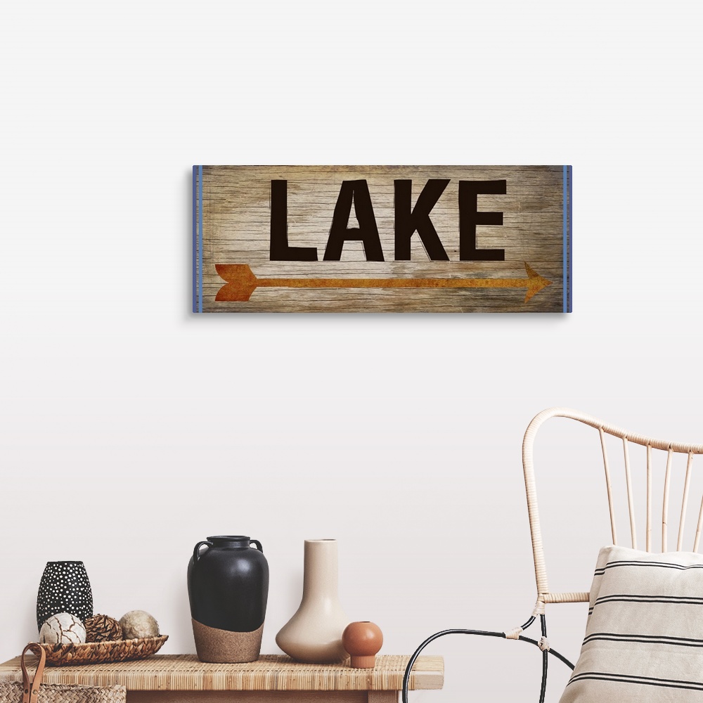 A farmhouse room featuring Wooden sign with an orange arrow, 2 blue lines on each side, and the word "Lake" written across it.