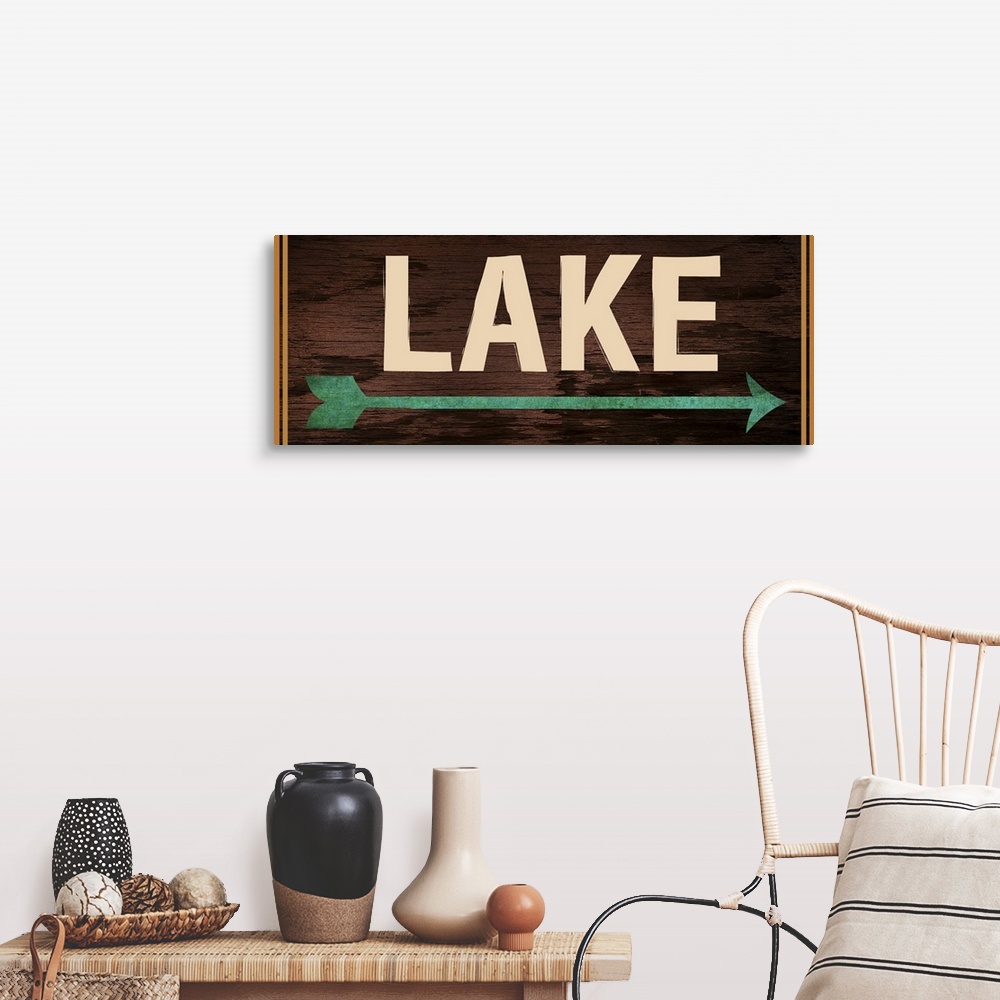 A farmhouse room featuring Dark wooden sign with a teal arrow, 2 orange lines on each side, and the word "Lake" written acro...