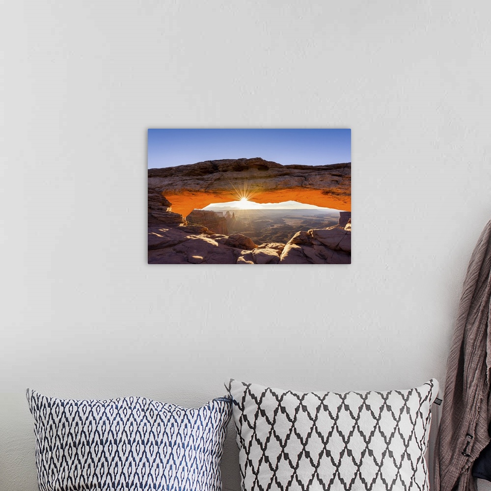 A bohemian room featuring A photograph of the Mesa arch in Canyonlands national park.