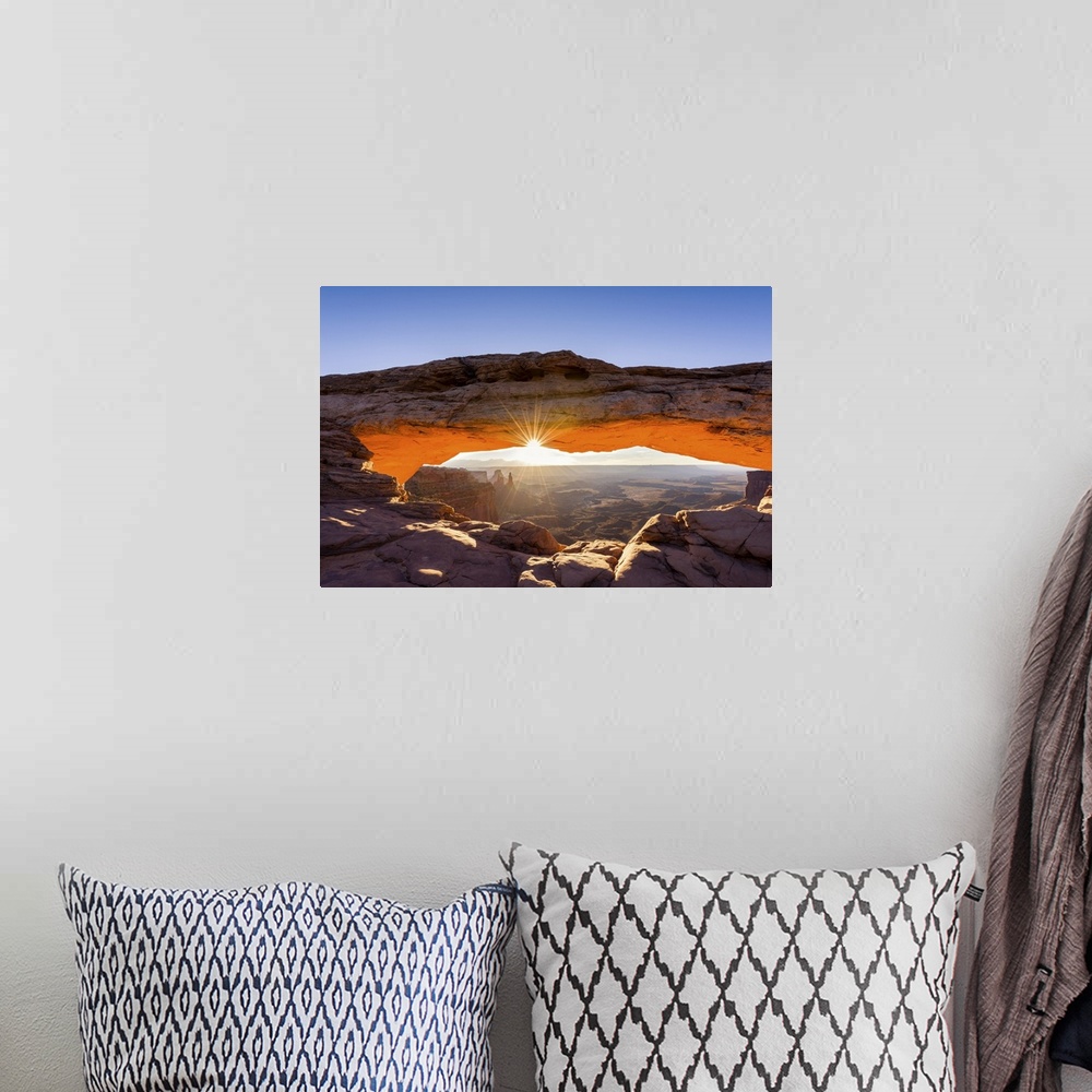 A bohemian room featuring A photograph of the Mesa arch in Canyonlands national park.