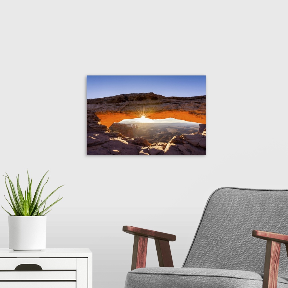 A modern room featuring A photograph of the Mesa arch in Canyonlands national park.