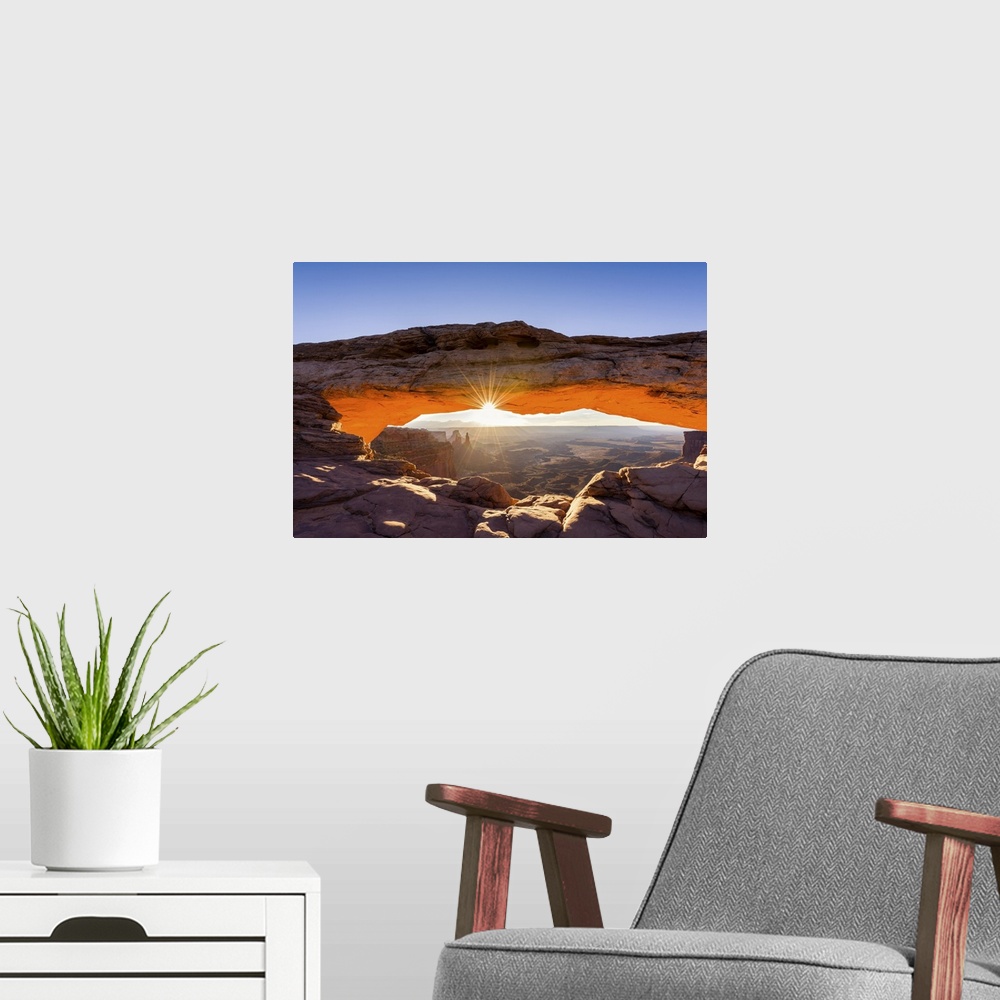 A modern room featuring A photograph of the Mesa arch in Canyonlands national park.