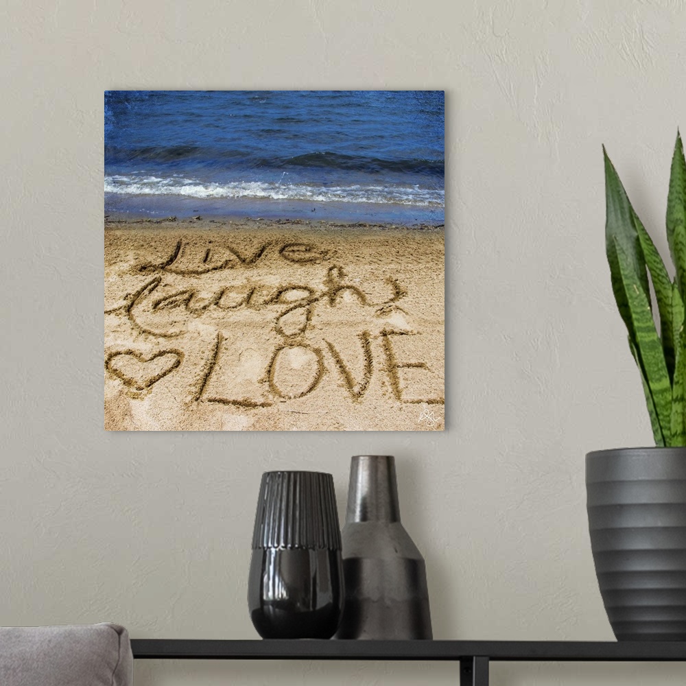 A modern room featuring Photograph of a motivational sentiment written in the sand on a beach.