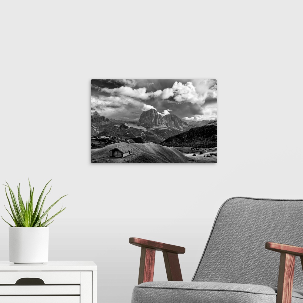 A modern room featuring Black and white photograph of a lone cabin surrounded by rolling hills and mountains with a cloud...