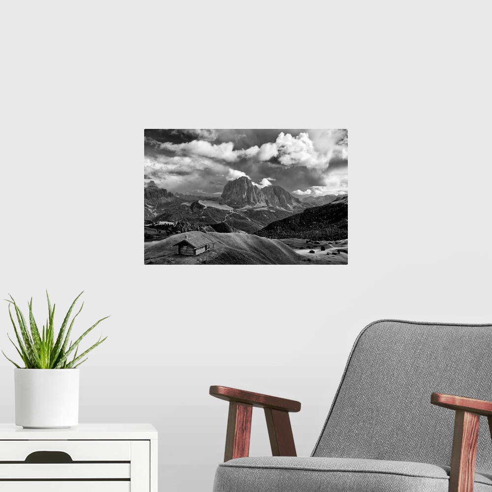 A modern room featuring Black and white photograph of a lone cabin surrounded by rolling hills and mountains with a cloud...