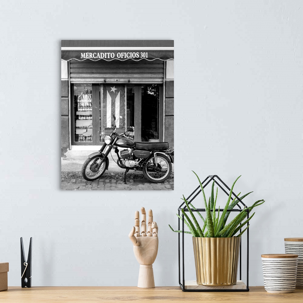 A bohemian room featuring motorcycle parked on cobblestone 
in front of Puerto Rican storefront
