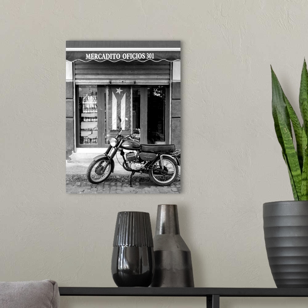 A modern room featuring motorcycle parked on cobblestone 
in front of Puerto Rican storefront