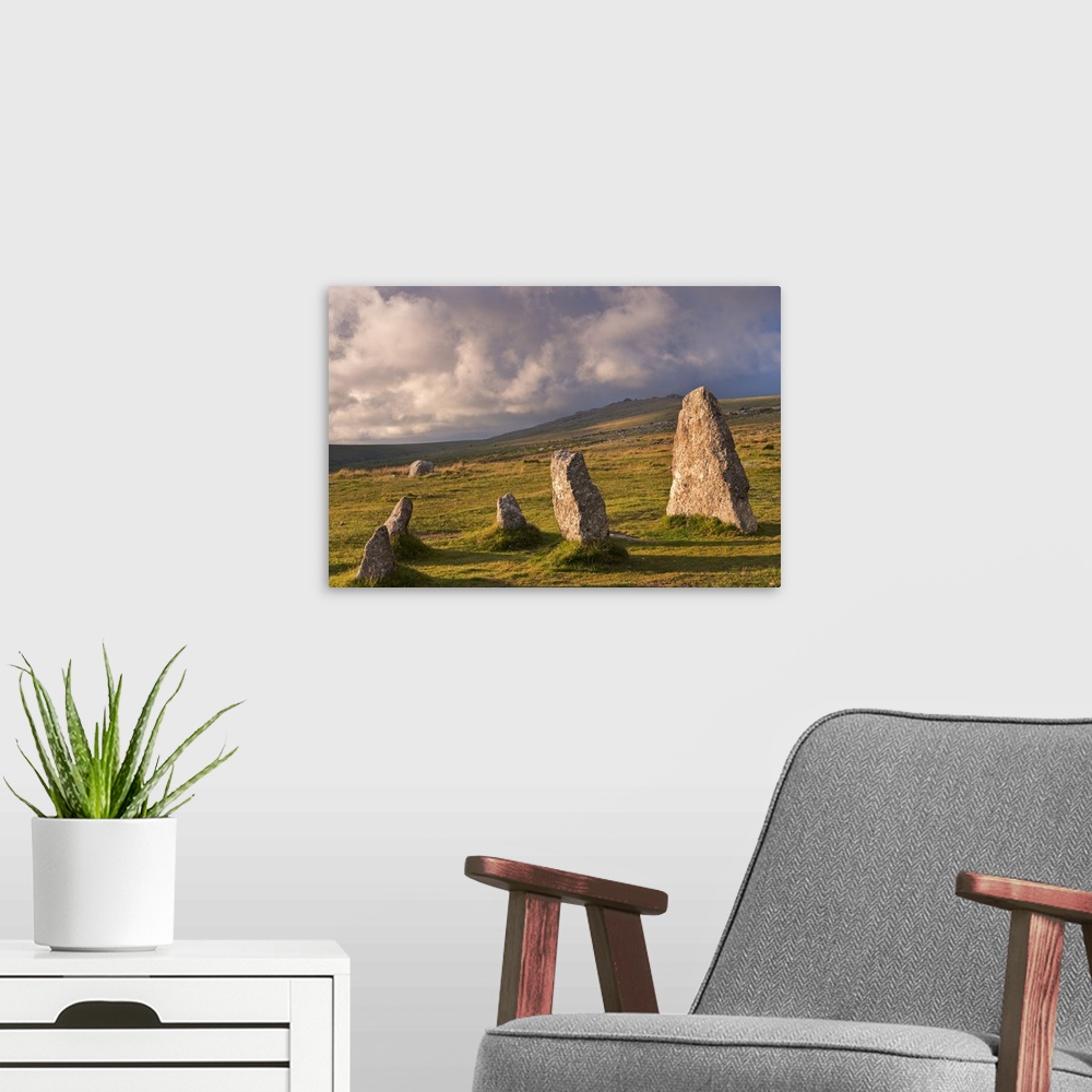 A modern room featuring Standing stones in a grassy meadow with cloudy skies.