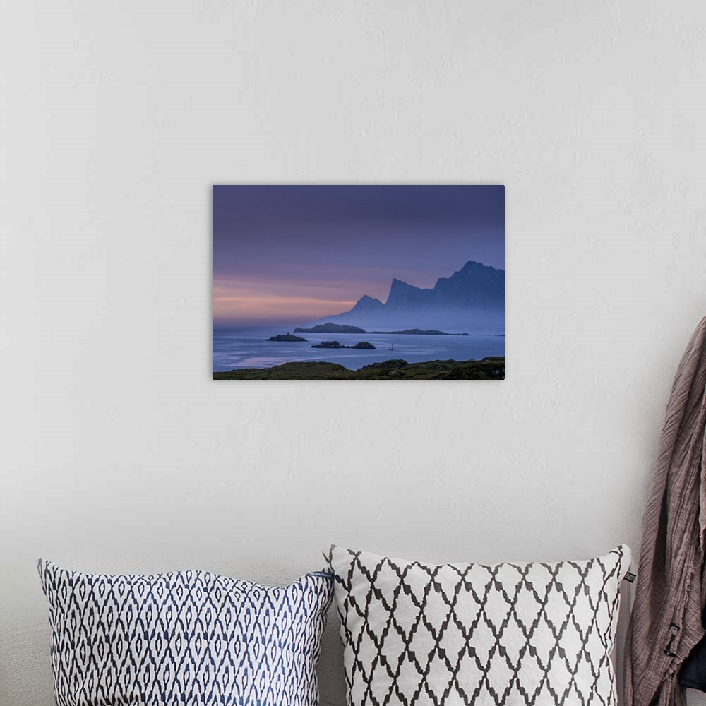 A bohemian room featuring A photograph of mountains cast in shadow from the light of the setting sun.