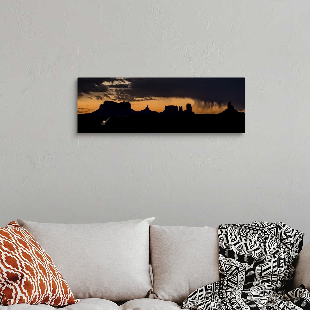 A bohemian room featuring A photograph of a silhouetted landscape under the dark clouds of an incoming storm.