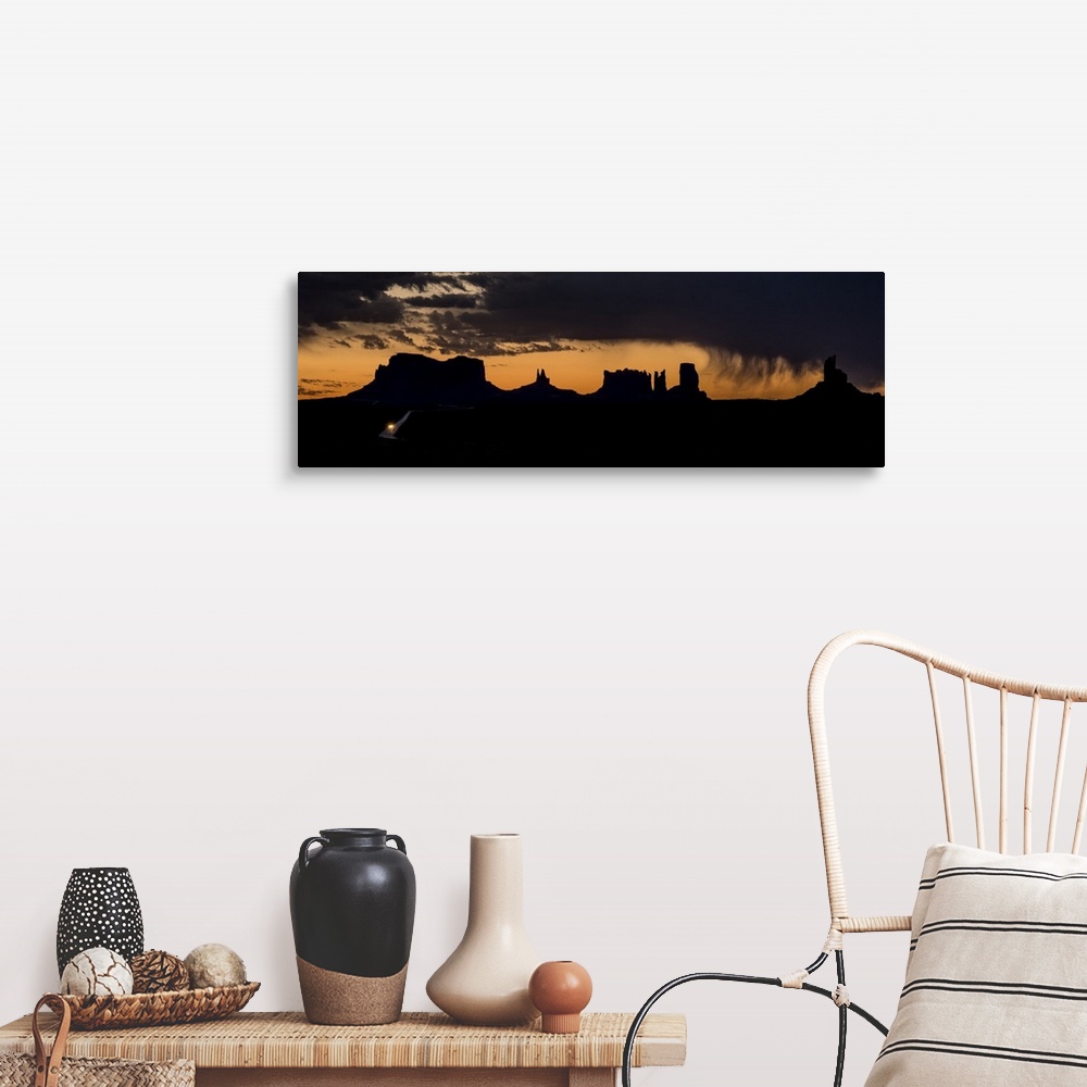 A farmhouse room featuring A photograph of a silhouetted landscape under the dark clouds of an incoming storm.