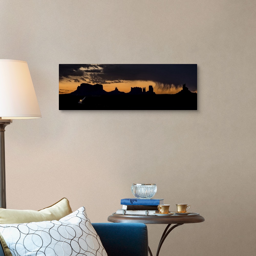 A traditional room featuring A photograph of a silhouetted landscape under the dark clouds of an incoming storm.
