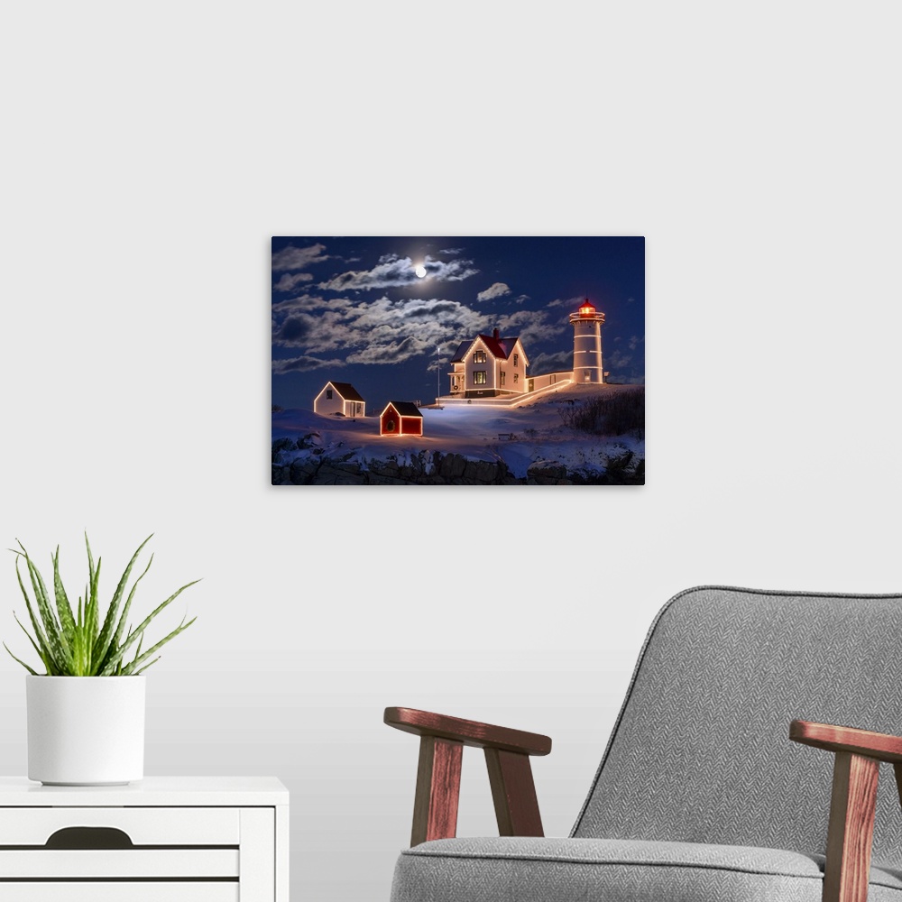 A modern room featuring Photograph of a lighthouse and other small building outlined in lights, under a bright moon and c...