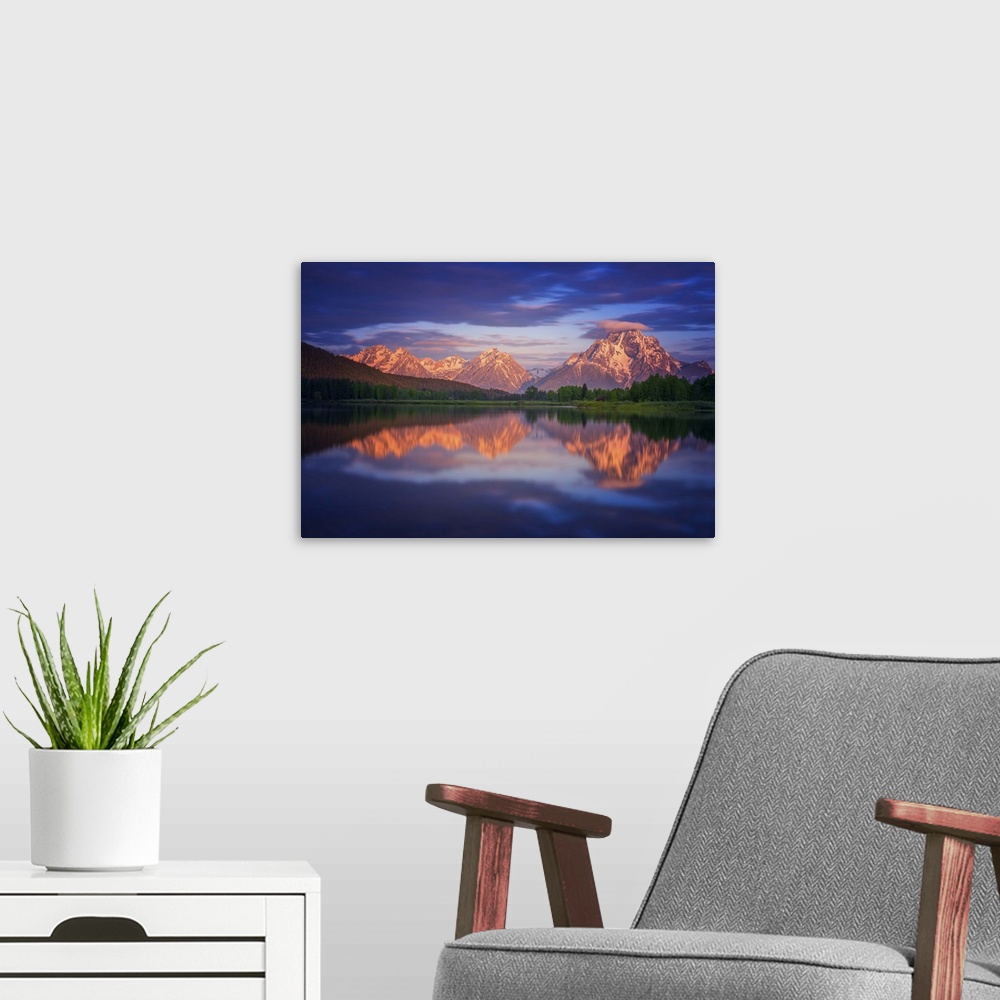 A modern room featuring Clouds over Mt. Moran at sunset, reflected in the lake below.