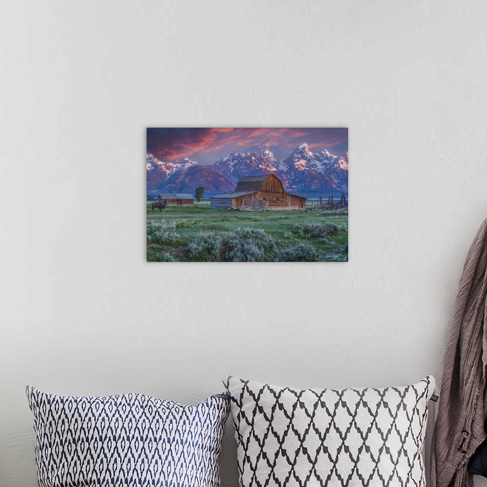 A bohemian room featuring A photograph of the Mormon Row Barn in Wyoming, with the Teton mountains in the background.