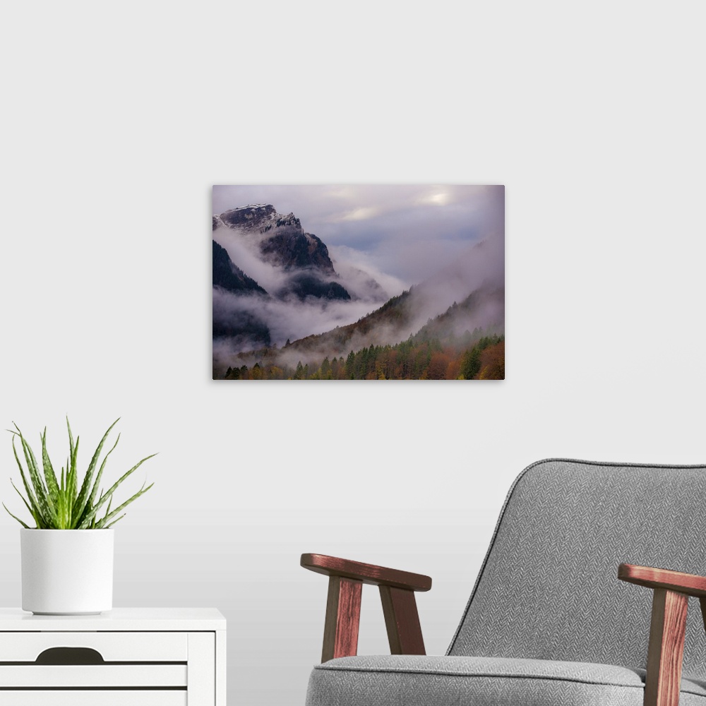 A modern room featuring A photograph of a mountain valley covered in deep with thick fog shrouding the area.