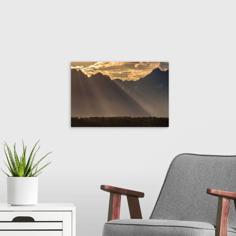 A modern room featuring A photograph of mountains cast in shadow from the light of the setting sun.