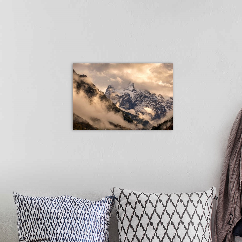 A bohemian room featuring Beautiful landscape photograph of snowy mountain peaks engulfed in clouds.