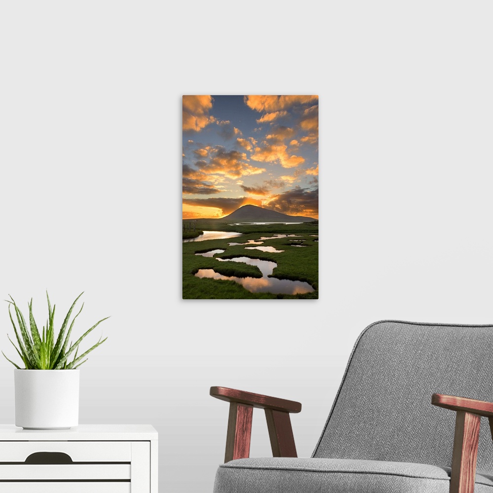 A modern room featuring Landscape photograph of a sunrise beaming though a mountain with a marsh in the foreground.