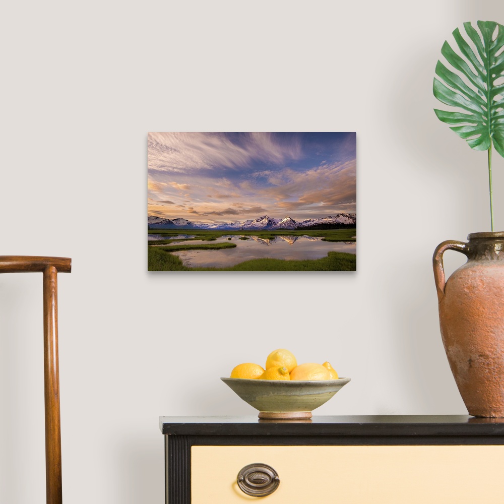 A traditional room featuring A photograph of mountain under dramatic clouds illuminated by the sunset.