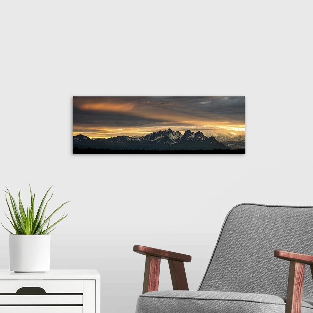 A modern room featuring A photograph of mountains cast in shadow from the light of the setting sun.
