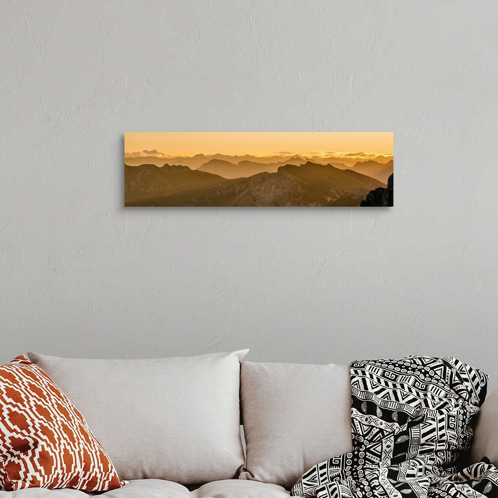 A bohemian room featuring Golden landscape photograph of snowy mountain tops going back into the distance as far as you can...