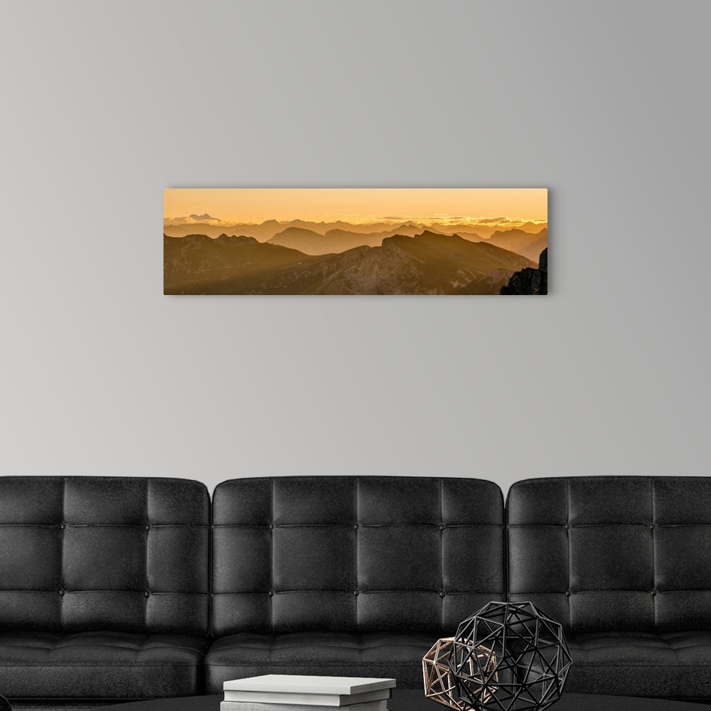 A modern room featuring Golden landscape photograph of snowy mountain tops going back into the distance as far as you can...
