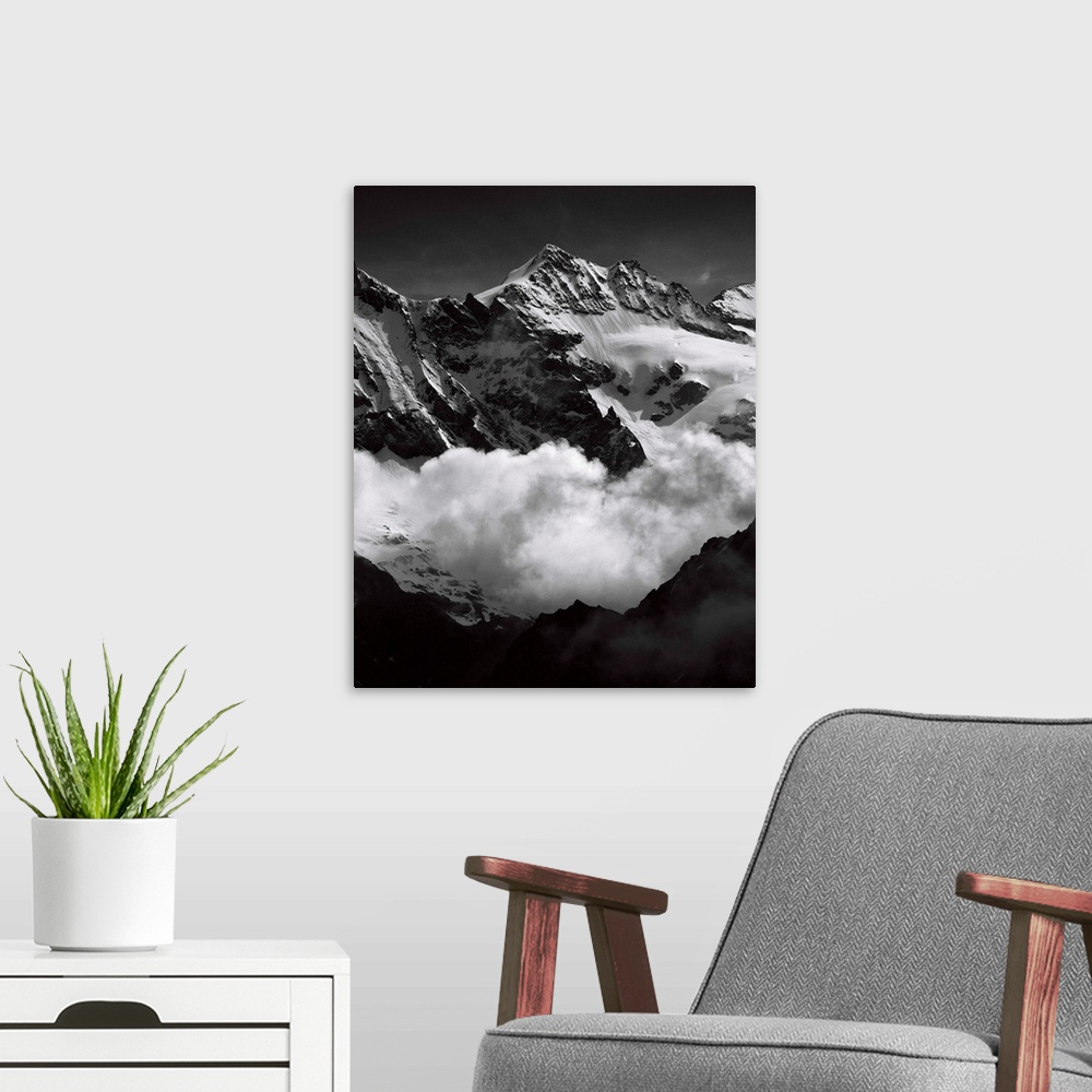 A modern room featuring Black and white photograph of mountain peaks surrounded by rolling clouds.