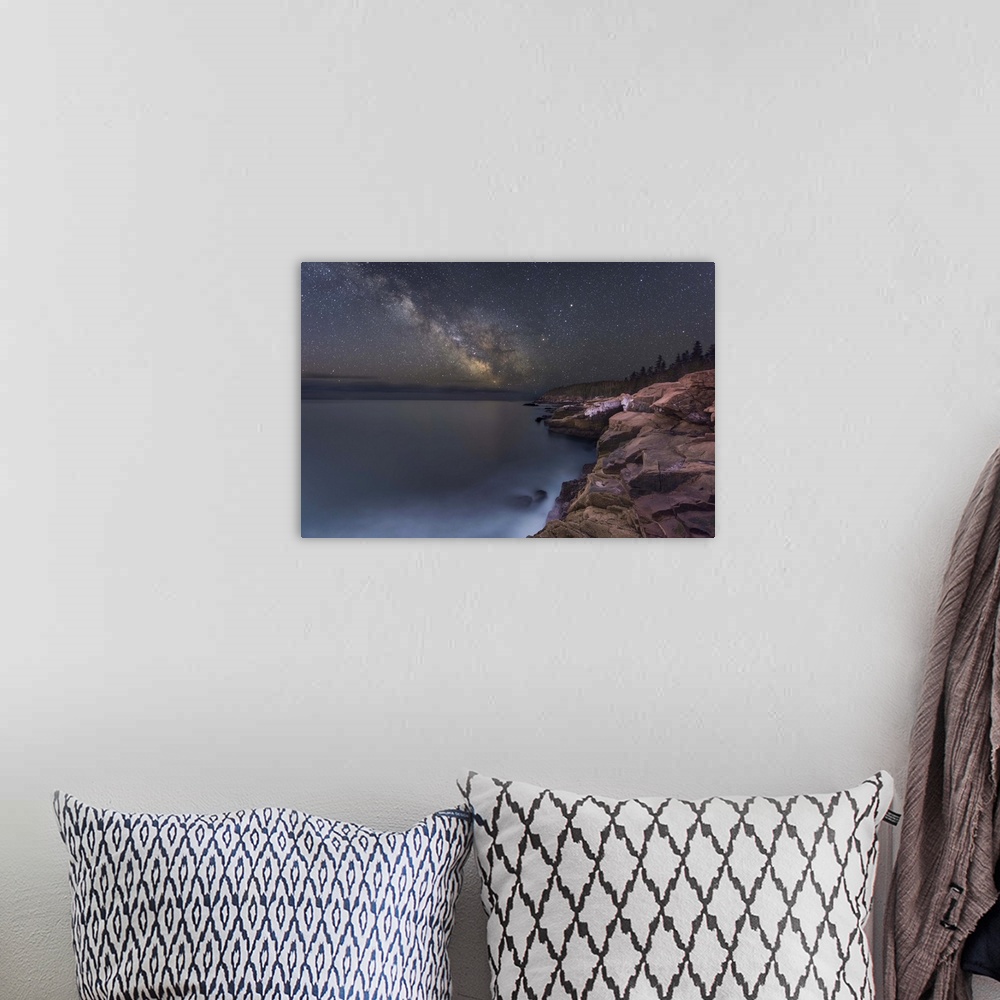A bohemian room featuring A photograph of a rocky coastline under a starry night sky.